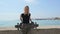 Beautiful and style young girl posing with a skateboard at seafront