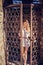Beautiful stylish girl in a fashionable summer dress posing at the old lattice gate in the fortress