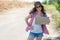 Beautiful stylish girl hitchhiker with loose hair in a baseball cap and sunglasses stands on the road with a cardboard