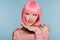 Beautiful stylish girl smiling, gesturing and posing in pink wig isolated