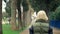 Beautiful stylish trendy blond woman walking in a city park in autumn