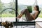 Beautiful stylish woman reading book on chair at firewood at window with view on mountain hills