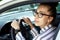 Beautiful successful smiling rich business woman in white suit sitting in gray car salon , wearing glasses talking on