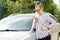 Beautiful successful smiling rich business woman in white suit sitting in gray car salon , wearing glasses talking on