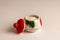 A beautiful sugar bowl with painted strawberries and a red lid, filled with white sugar on a white background