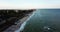 Beautiful summer aerial 4k video. Overhead view of people walking by the sandy beach along blue ocean