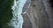 Beautiful summer aerial 4k video. Overhead view of people walking by the sandy beach along the blue ocean