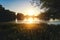 Beautiful summer autumn landscape, the sun sets in the forest, a view of the trees and grass pond, reflected in the water.