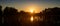 Beautiful summer autumn landscape, the sun sets in the forest, a view of the trees and grass pond, reflected in the water.