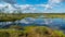 Beautiful summer bog landscape with lake, moss, bog pines and birches, peat bog flora