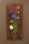 A beautiful summer bouquet, wildflowers, wild onions, Veronica long-leaved violet on a wooden background of black walnut.