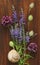 A beautiful summer bouquet, wildflowers, wild onions, Veronica long-leaved violet on a wooden background of black walnut.