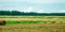 Beautiful Summer Farm Scenery with Haystacks. Field Landscape with Rolls and Sky.