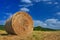 Beautiful summer landscape. Agricultural field. Round bundles of dry grass in the field with bleu sky and sun. Hay bale - haystack