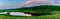 Beautiful summer landscape, beautiful view of the lake, surrounded by meadows and green forest. Blue sky over plain, panoramic