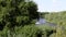 A beautiful summer landscape with a view of a large river along which jet skis float.