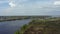 Beautiful summer natural background. Flight of the copter over the river, fields and forests of Russia.