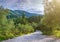 Beautiful summer panoramic landscape. Cypress hills and green mountain slopes. The road going through the thickets of subtropical