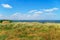 Beautiful summer seascape, seashore on a bright day, high hill and wild grass