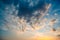 Beautiful summer sky full of clouds at sunset at golden hour. Interesting warm colors on the horizon