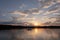 beautiful summer sunset on the lake with a floating boat with people