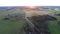 Beautiful summer sunset. Road / alley. Green fields and forest. Aerial footage.