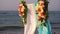 Beautiful summer wedding ceremony outdoors. Wedding arch made of light cloth and white and pink flowers on sea