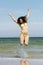 Beautiful summer woman in swimsuit jumping over seaside.