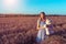 Beautiful summer woman wheat field, blue dress, hands of children`s toy teddy bear. Free space for text. Rest rural