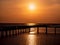 Beautiful sun Wooded bridge pole in the port between sunrise against orange sky calm peaceful moment relax holiday concept idea