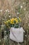 Beautiful sunflowers in straw bag in summer meadow in evening. Tranquil atmospheric moment in countryside. Gathering sunflowers