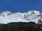 Beautiful sunlight and snow-capped alpine peaks above the Swiss tourist sports-recreational winter resorts