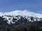 Beautiful sunlight and snow-capped alpine peaks above the Swiss tourist sports-recreational winter resorts