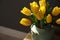 Beautiful sunlit bouquet with yellow tulips on table, closeup