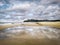 The beautiful sunny day on the beach and the water reflection of the blue sky.