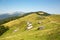 Beautiful sunny day in Carpathian Mountains. Nature in Carpathians. Green meadows, forests and little houses in mountains.