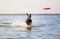 On the beautiful sunny day at the lake the playful dog is jumping from the water. Splashes and waves. Silhouette reflection.