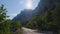 Beautiful sunny road through a mountain pass among evergreens trees and pines