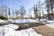 Beautiful sunny spring landscape. Natural granit grey walkway.Beautiful  outdoor sitting park area. Cold snow conditions