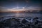 Beautiful sunrays above the atlantic ocean with stones, Acores