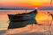 Beautiful sunrise with a boat reflected on the lake