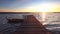 Beautiful sunrise. Boat and wooden jetty on lake with a reflection in the water at sunset