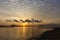 A beautiful sunrise with cloudy sky on the beach.