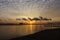 A beautiful sunrise with cloudy sky on the beach.