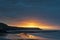 Beautiful sunrise landscape image of Kennack Sands in Cornwall UK wuth dramatic moody clouds and vibrant sunburst