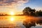 Beautiful sunrise over the lake with a tree reflected in the water