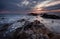 Beautiful sunrise over the sea. Cloudy dramatic sky, big waves. Magnificent cloudscape near the shore