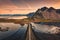 Beautiful sunrise over Vestrahorn mountain with road into the black sand beach in Atlantic ocean at Stokksnes on the southeastern