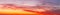 Beautiful sunrise panorama with cloud formations in orange and yellow colors