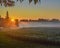 Beautiful Sunrise with Rays in Fog over Soybean Field